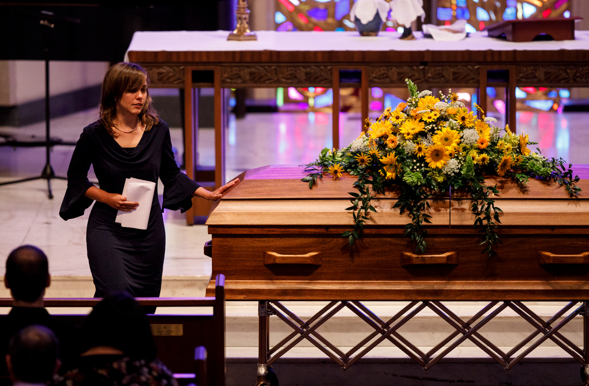 Amanda Held Opelt touches the casket of her sister, author Rachel Held Evans, during her funeral at First-Centenary United Methodist Church on Saturday, June 1, 2019, in Chattanooga, Tenn. Evans was a Dayton, Tenn., resident who authored books including "A Year of Biblical Womanhood," "Searching for Sunday" and "Inspired: Slaying Giants, Walking on Water, and Loving the Bible Again."