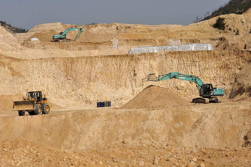 In this Dec. 30, 2010, photo, workers use machinery to dig at a rare earth mine in Ganxian county in central China's Jiangxi province. Facing new trade sanctions and a U.S. clampdown on its top telecommunications company, China issued a pointed reminder on Wednesday, May 30, 2019 that it has yet to unleash all its weapons in its trade war with the Trump administration. Chinese state media warned that Beijing could cut America off from exotic minerals that are widely used in electric cars and mobile phones. The threat to use China's rich supply of so-called rare earths as leverage in the conflict has contributed to sharp losses in U.S. stocks and sliding long-term bond yields. (Chinatopix via AP)