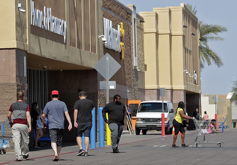 In this June 3, 2019, photo, shoppers enter and exit a Walmart in Tempe, Ariz. Executives at Walmart and dollar-store chains, which import much of their merchandise and serve many low-income customers, have warned that tariffs could lead to higher prices for consumers. (AP Photo/Matt York)