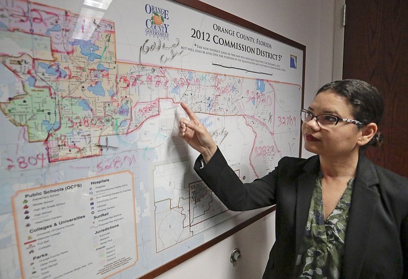 In this Monday, June 3, 2019, photo, Orange County Commissioner Emily Bonilla looks at a map of Orange County and the city of Orlando in Orlando, Fla. Bonilla is worried her district in metro Orlando will be undercounted during next spring's once-in-a-decade head count of everybody in the United States because of who lives there: new arrivals, immigrants, the poor, renters and people living in rural areas who sometimes regard government with suspicion. (AP Photo/John Raoux)

