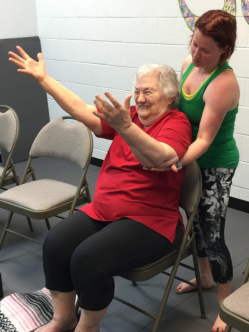 Stroke patient Rachel Waters (seated) works with yoga instructor Maggie Bailey. 