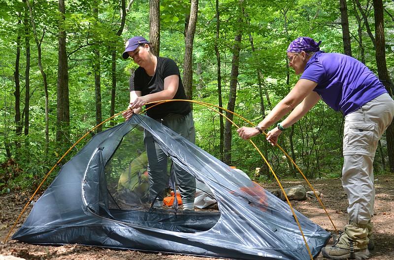 Lauren O'Neill, left, is being helped by group leader Laura Seeger in putting up her tent for the Trail Dames backpacking trip last Saturday night. It was O'Neill's first time to backpack.