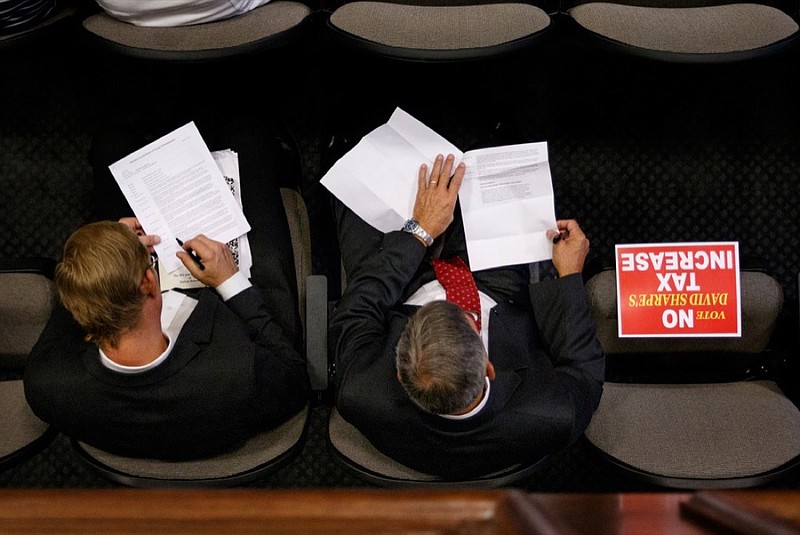 Ron Ray, right, and Chris Dahl sit with a sign reading "No Tax Increase" during a meeting of the Hamilton County Commission at the Hamilton County Courthouse on Wednesday. Hamilton County Mayor Jim Coppinger's budget calls for a tax increase for additional funding for schools.