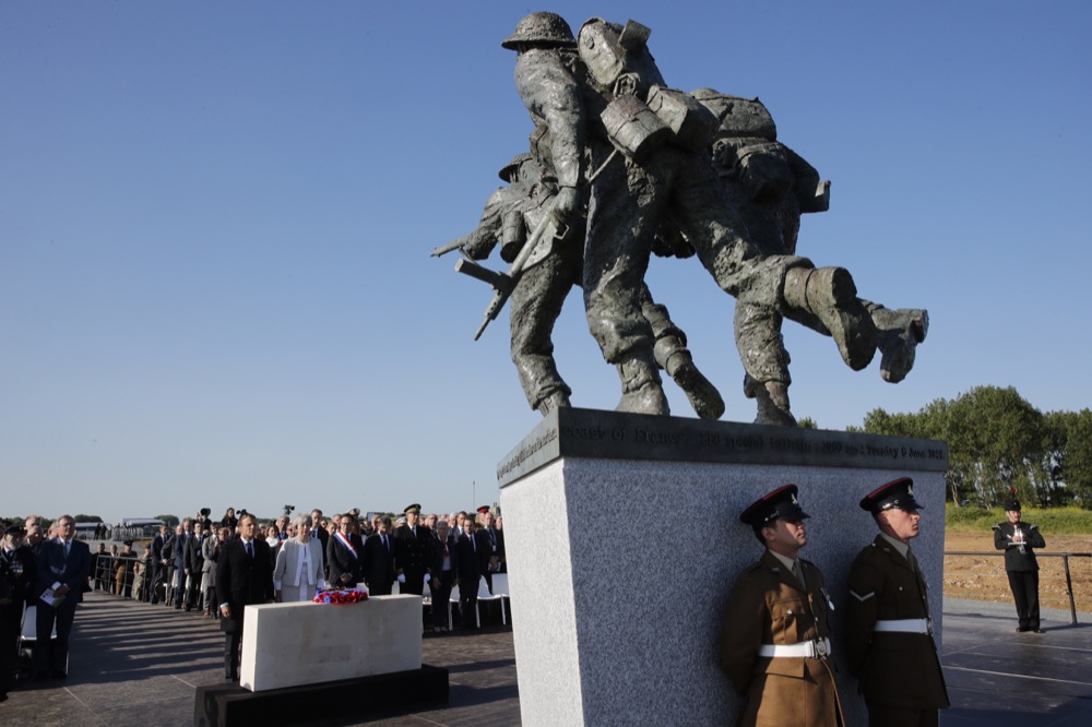 British Prime Minister Theresa May and French President Emmanuel Macron attend a Franco-British ceremony marking the 75th anniversary of D-Day landings at Ver-Sur-Mer, Normandy, Thursday, June 6, 2019.(Philippe Wojazer/Pool via AP)