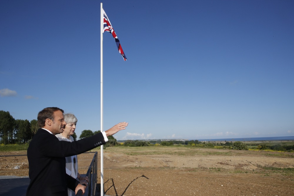 British Prime Minister Theresa May and French President Emmanuel Macron talk after a Franco-British ceremony marking the 75th anniversary of D-Day landings at Ver-Sur-Mer, Normandy, Thursday, June 6, 2019.(Philippe Wojazer/Pool via AP)