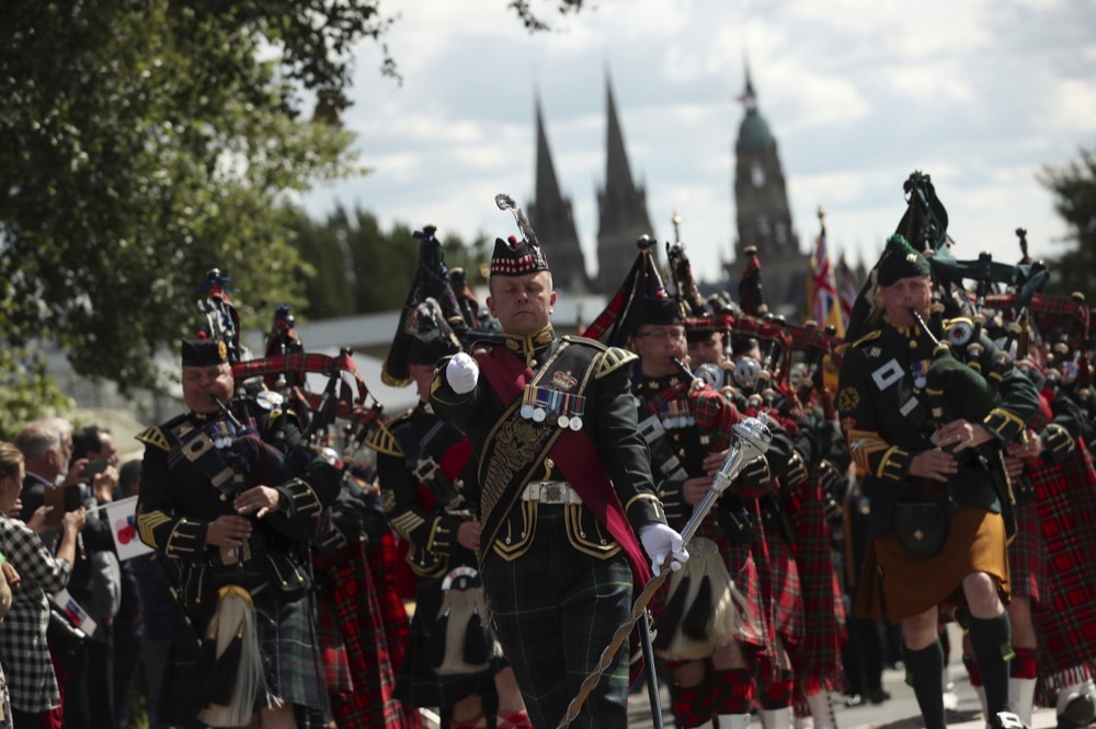 Bagpipers lead a procession of British World War II veterans to the Bayeux War Cemetery for a ceremony to mark the 75th anniversary of D-Day in Bayeux, Normandy, France, Thursday, June 6, 2019. World leaders gathered Thursday in France to mark the 75th anniversary of the D-Day landings.(AP Photo/Francisco Seco)