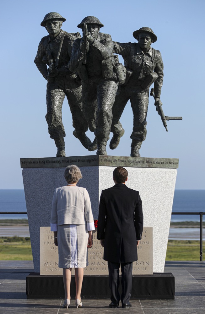 French President Emmanuel Macron and British Prime Minister Theresa May face the new sculpture at the British Normandy Memorial during a Franco-British ceremony to mark the 75th anniversary of D-Day landings at Ver-Sur-Mer, Normandy, France, Thursday, June 6, 2019. (Ben Shread, MOD via AP)