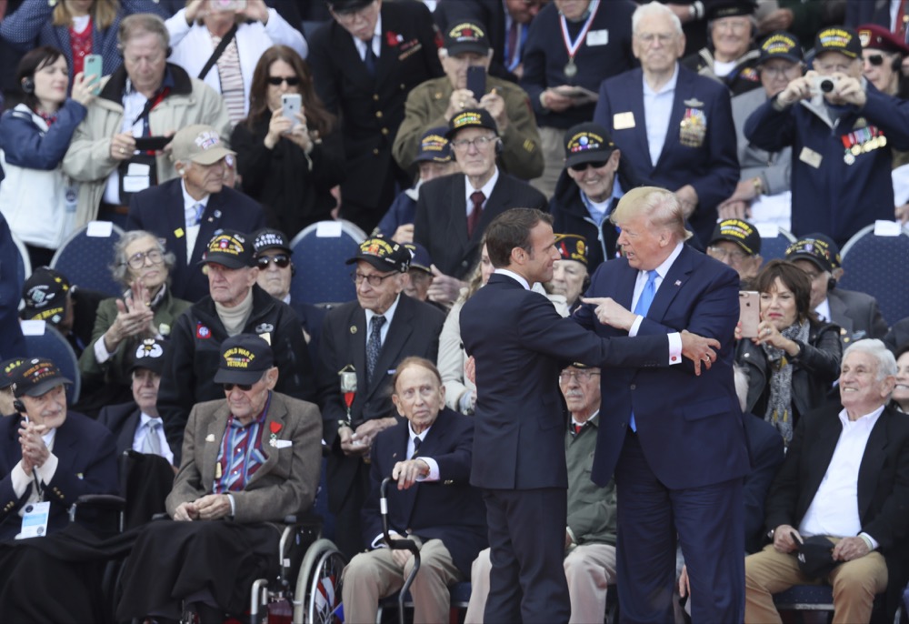 U.S. President Donald Trump, right, and French President Emmanuel Macron speak with each other during a ceremony to mark the 75th anniversary of D-Day at the Normandy American Cemetery in Colleville-sur-Mer, Normandy, France, Thursday, June 6, 2019. World leaders are gathered Thursday in France to mark the 75th anniversary of the D-Day landings. (AP Photo/David Vincent)