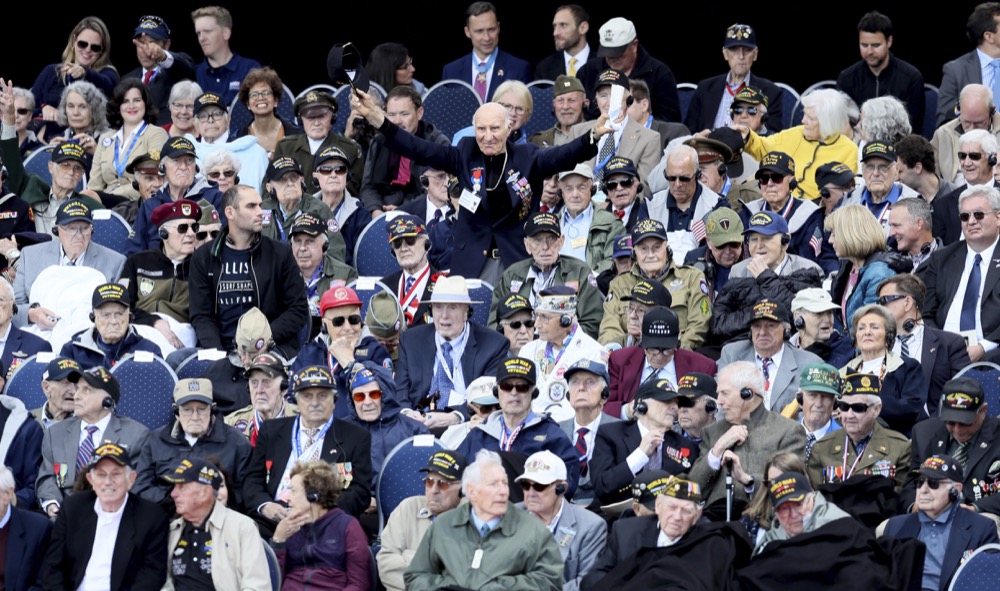 U.S. World War II veteran Jacques Michienzi, center, stands up among other veterans during a ceremony to mark the 75th anniversary of D-Day at the Normandy American Cemetery in Colleville-sur-Mer, Normandy, France, Thursday, June 6, 2019. World leaders are gathered Thursday in France to mark the 75th anniversary of the D-Day landings. (AP Photo/David Vincent)
