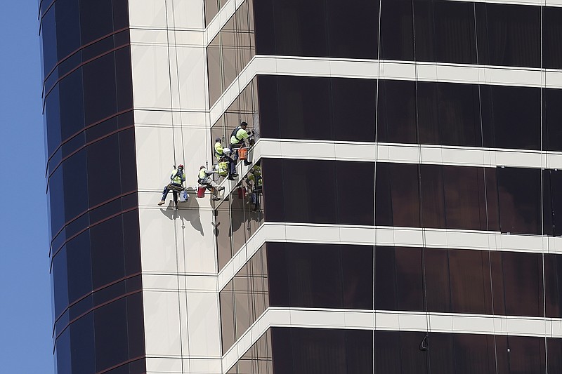 FILE - In this May 22, 2019, file photo window washers work on Encore Boston Harbor in Everett, Mass. On Thursday, June 6, the Labor Department issues revised data on productivity in the first quarter. (AP Photo/Michael Dwyer, File)