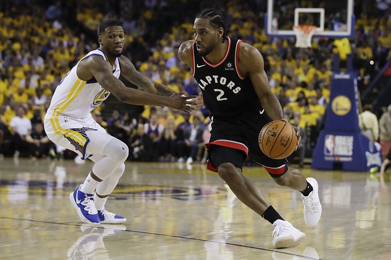 Toronto Raptors forward Kawhi Leonard dribbles while guarded by Golden State Warriors forward Alfonzo McKinnie during the first half of Game 3 of the NBA Finals on Wednesday night in Oakland, Calif.