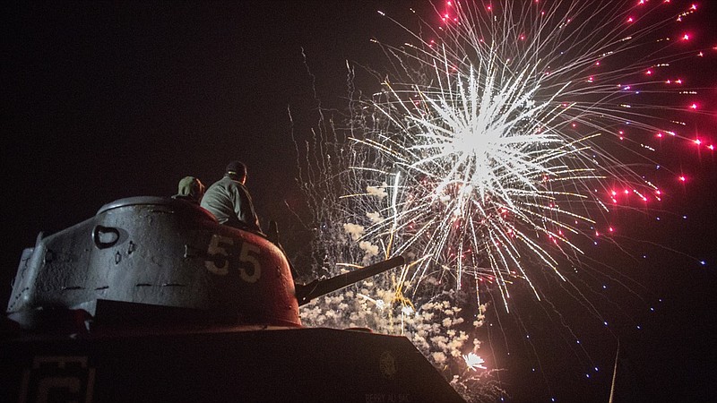 People on a tank watch fireworks in Arromanches in Normandy region of France, Thursday, June 6, 2019. World leaders and veterans gathered Thursday in France to mark the 75th anniversary of the D-Day landings. (AP Photo/Rafael Yaghobzadeh)