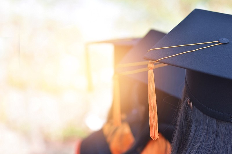 The back image of the graduates wearing a yellow tassel hat. grad tile graduation tile / Getty Images