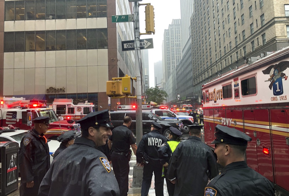 New York police officers monitor the streets near 787 7th Ave., Monday, June 10, 2019, in New York, where a helicopter was reported to have crash landed on top of a building in midtown Manhattan. The FDNY said at around 2 p.m. Monday that it had no further details of the incident, roughly located around 51st Street and Seventh Avenue. (AP Photo/Mark Lennihan)