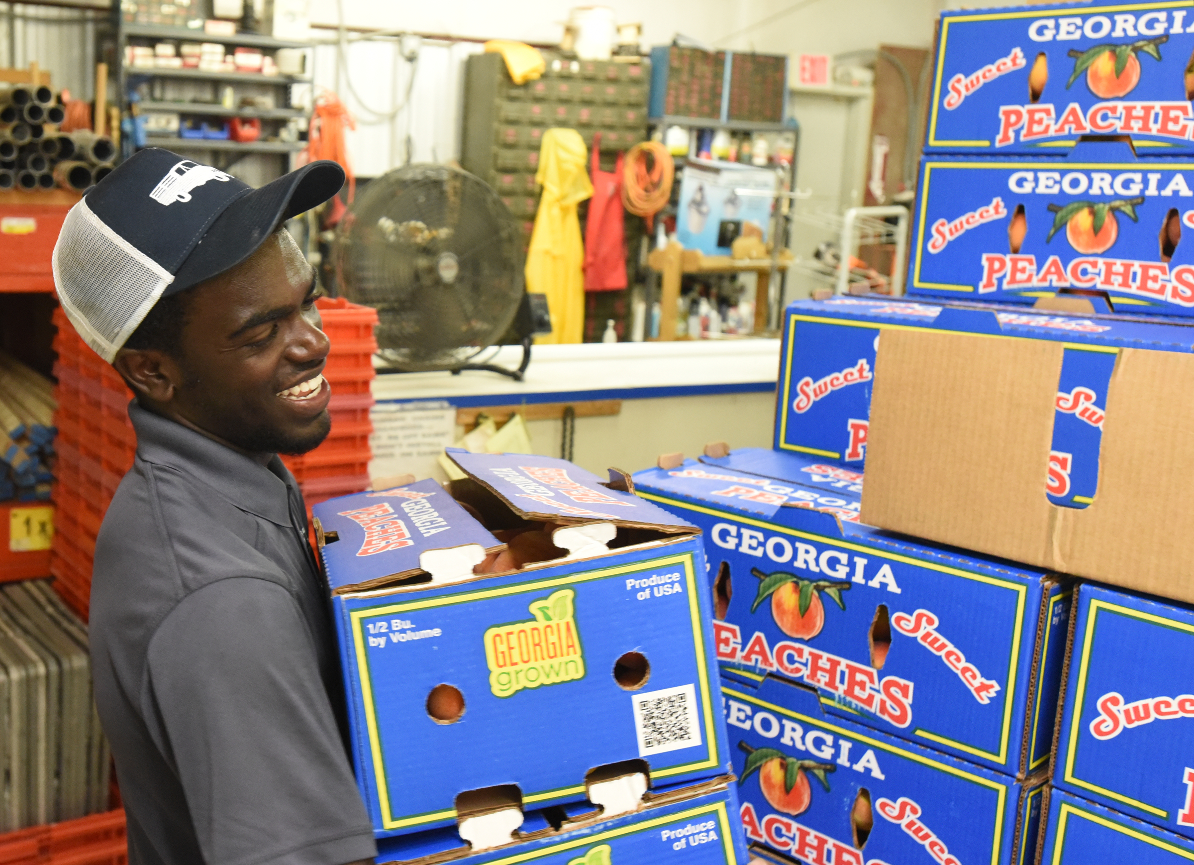 Joseph Kudratt of The Peach Truck hands out boxes of peaches to customers at East Ridge Hardware during a 2016 stop.