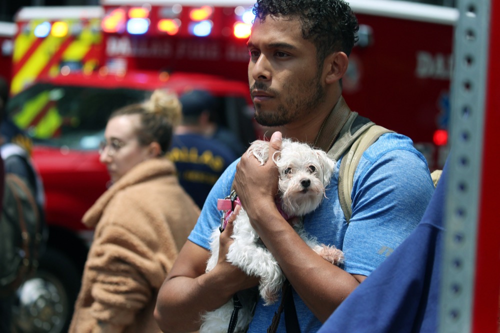Isaiah Allen, a resident of the damaged apartments, holds onto a dog, Princess, as he watches officials respond to a scene after a crane collapsed into Elan City Lights apartments in Dallas on Sunday, June 9, 2019. Allen was in his apartment when he said he heard what he thought was the loudest thunderclap he had ever heard but quickly realized the sound came from the collapsed crane. (Photo by Shaban Athuman/ The Dallas Morning News)