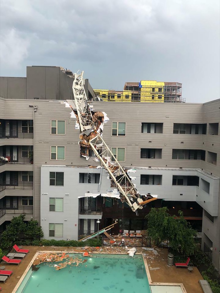 This photo taken and provided by Michael Santana shows a construction crane toppling on an apartment building as it was buffeted by high winds during a storm in Dallas, Texas, Sunday, June 9, 2019. (Michael Santana via AP)