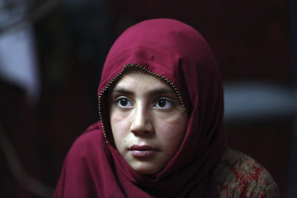 In this Thursday, May 30, 2019 photo, Shoghla, daughter of Farmanullah Shirzad whose family fled their village in Nangarhar province in late April as Islamic State group fighters swept through the area, poses for a photograph in their temporary home in the city of Jalalabad east of Kabul, Afghanistan. The Islamic State group has lost its caliphate in Syria and Iraq, but in the forbidding mountains of northeastern Afghanistan the group is expanding its footprint, recruiting new fighters and plotting attacks in the United States and other Western countries. (AP Photo/Rahmat Gul)