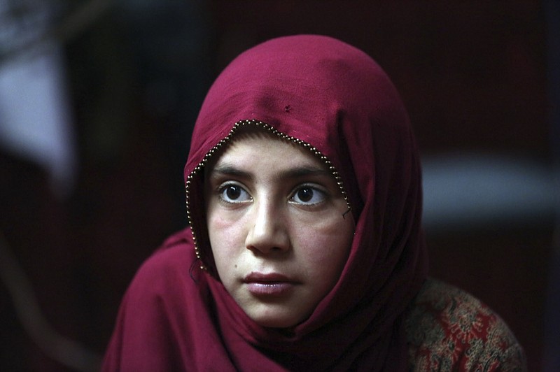 In this Thursday, May 30, 2019 photo, Shoghla, daughter of Farmanullah Shirzad  whose family fled their village in Nangarhar province in late April as Islamic State group fighters swept through the area, poses for a photograph in their temporary home in the city of Jalalabad east of Kabul, Afghanistan. The Islamic State group has lost its caliphate in Syria and Iraq, but in the forbidding mountains of northeastern Afghanistan the group is expanding its footprint, recruiting new fighters and plotting attacks in the United States and other Western countries. (AP Photo/Rahmat Gul)