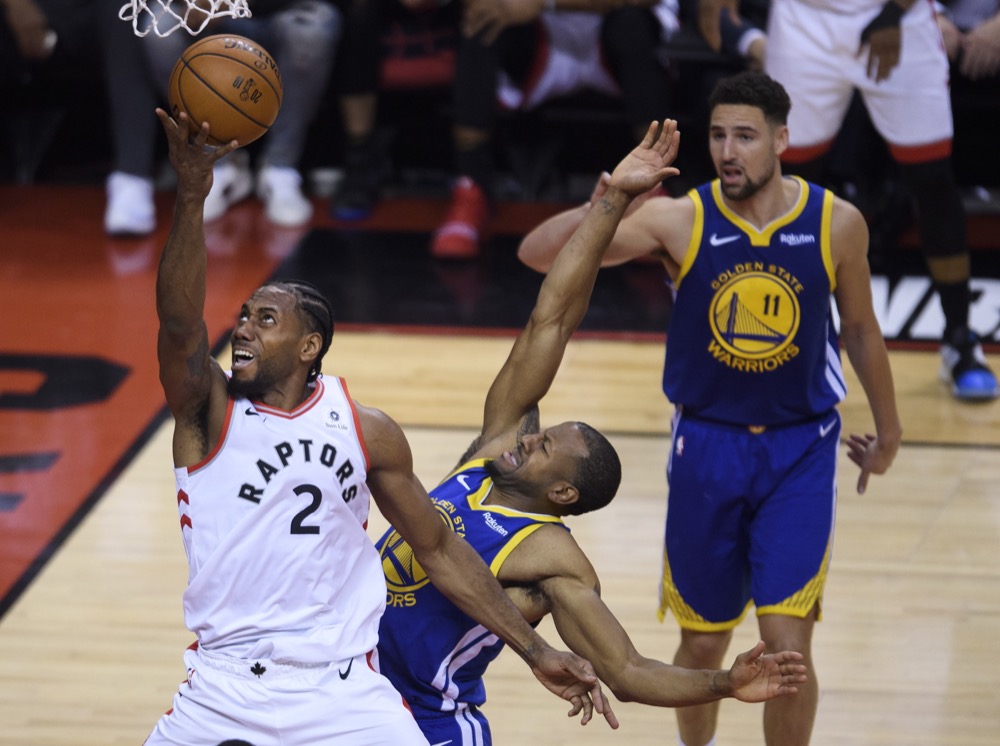 Toronto Raptors forward Kawhi Leonard (2) drives past Golden State Warriors forward Andre Iguodala during first-half basketball action in Game 5 of the NBA Finals in Toronto, Monday, June 10, 2019. (Nathan Denette/The Canadian Press via AP)