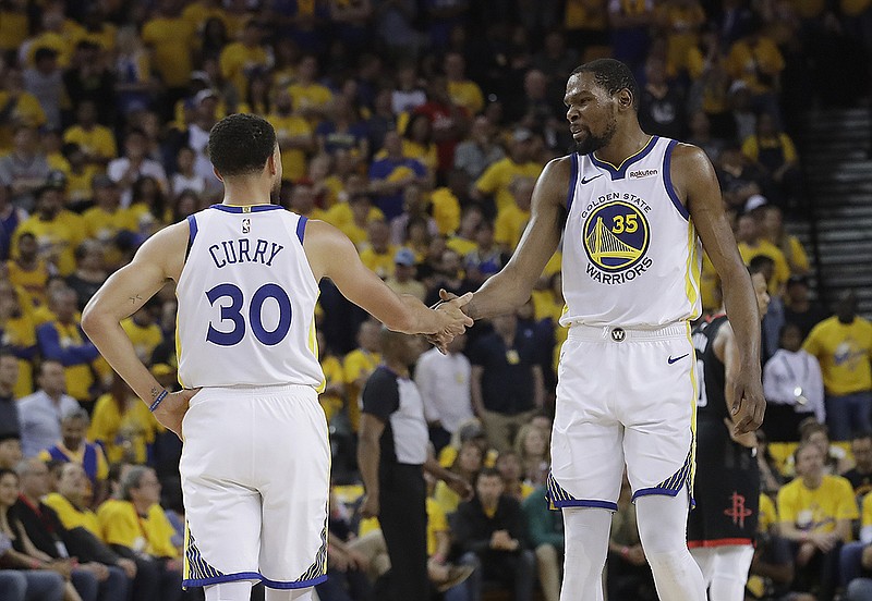 Golden State Warriors guard Stephen Curry and forward Kevin Durant talk during the opening game of their team's second-round playoff series against the Houston Rockets on April 28.