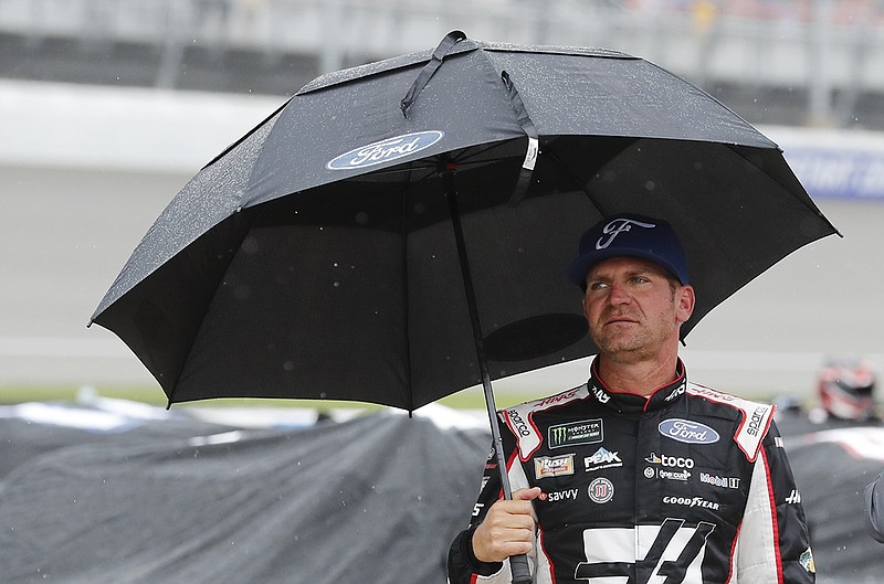 NASCAR Cup Series driver Clint Bowyer stands on pit row Sunday at Michigan International Speedway after the race's original start time was pushed back because of rain. The race was eventually rescheduled for Monday.