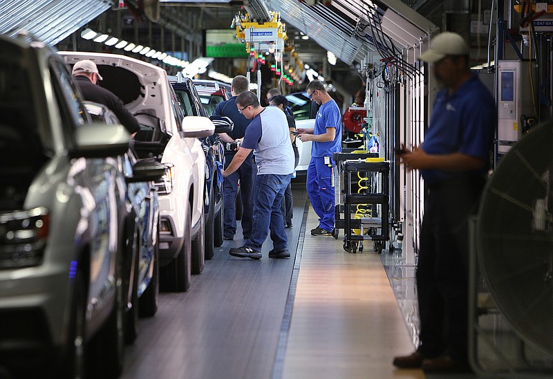 Staff file photo by Erin O. Smith / Volkswagen employees perform checks as vehicles move down the assembly line at the Chattanooga plant. Each vehicle goes through variety of inspections before reaching the end of the production line.