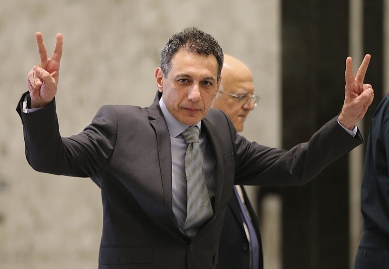 Nizar Zakka, a Lebanese citizen and U.S. permanent resident, who was released in Tehran after nearly four years in jail on charges of spying, flashes victory signs upon his arrival at the presidential palace, in Baabda, east of Beirut, Tuesday, June 11, 2019. Zakka a Lebanese businessman was allowed to fly to Lebanon, a development that comes amid heightened tensions between Iran and the U.S. after President Donald Trump withdrew America from Tehran's nuclear deal with world powers. (AP Photo/Hussein Malla)

