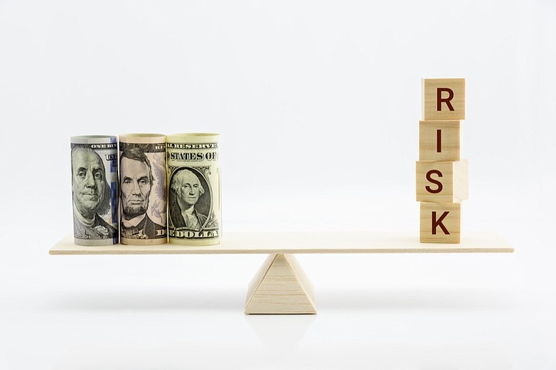 Financial, economic risk and risk perception, decision making concept : Dollar bills, risk wood blocks on a basic balance scale, depicts an uncertain event or condition that has an effect on objective money tile lending tile borrow money / Getty Images
