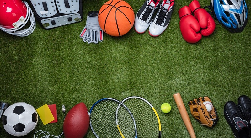 High Angle View Of Various Sport Equipments On Green Grass sports tile assorted sports equipment on grass sports rack / Getty Images
