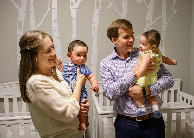 John Gandy, right, and his wife Jourdan hold their twin children in the nursery of their home on Tuesday, June 11, 2019, in Chattanooga, Tenn. John, who works for Unum, took the company's paid paternal leave plan following the birth of the twins.