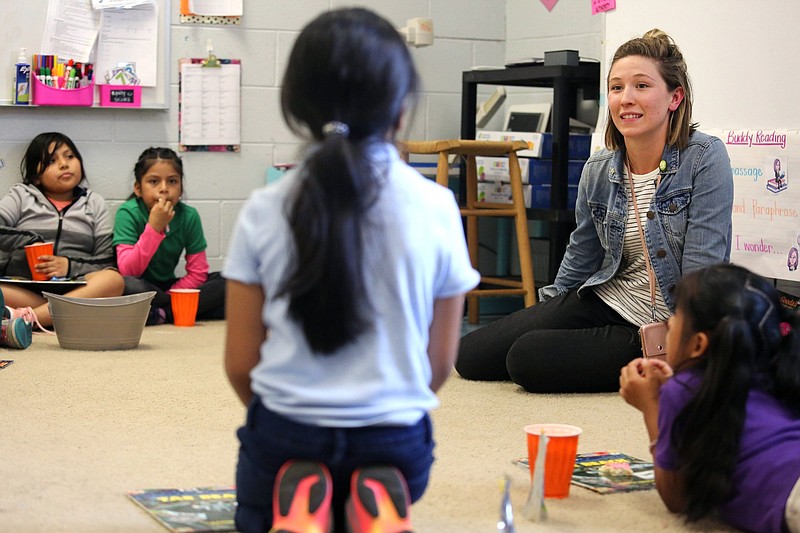 Catherine Casselman, a second-grade teacher at East Side Elementary School, listens to students as they talk about a book they're reading in their after school book club at East Side Elementary on April 18.