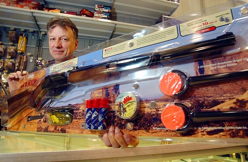 Little Rock, Ark., sporting goods store employee Matthew Waton poses with a Daisy Red Ryder BB gun package during the 2004 Christmas shopping season. Daisy's BB guns have been used to train decades of hunters and firearms enthusiasts, writes outdoors columnist Larry Case.