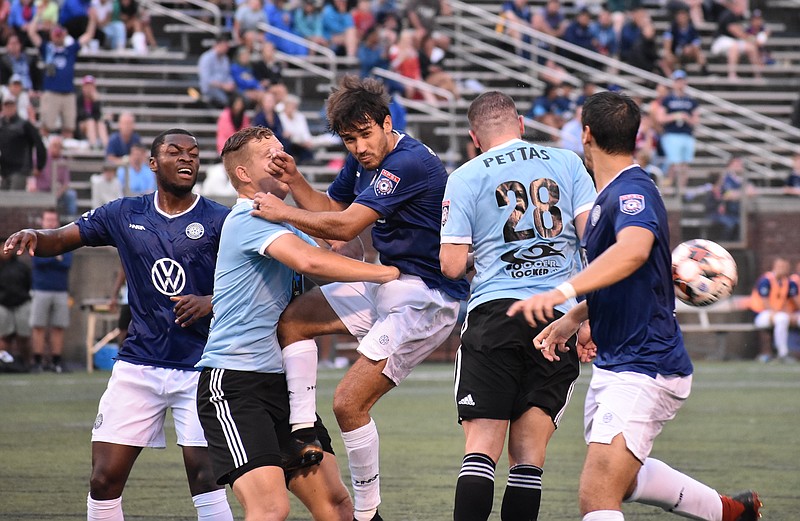 Chattanooga Football Club's Jose "Zeca" Ferraz, center, battles for the ball against Atlanta SC during an NPSL match Wednesday night at Finley Stadium. CFC won 3-0 for its second victory in five days.