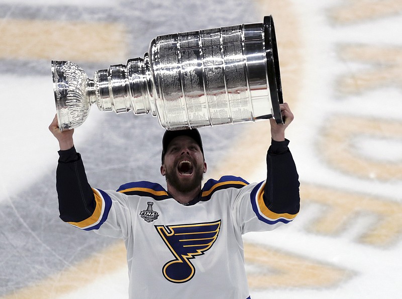 The St. Louis Blues' David Perron carries the Stanley Cup after the Blues defeated the Boston Bruins in Game 7 of the NHL title series Wednesday night in Boston.