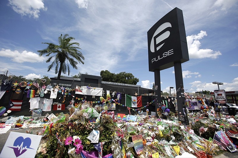 FILE - In this July 11, 2016, file photo, a makeshift memorial continues to grow outside the Pulse nightclub in Orlando, the day before the one month anniversary of a mass shooting, in Orlando, Fla. Floridians and others around the world are remembering the three-year anniversary of a massacre at the Pulse nightclub that left 49 people dead. Florida Gov. Ron DeSantis issued a proclamation for Wednesday, June 12, 2019 ordering state flags to be lowered to half-staff and asking Floridians to remember the victims of the shooting. (AP Photo/John Raoux, File)

