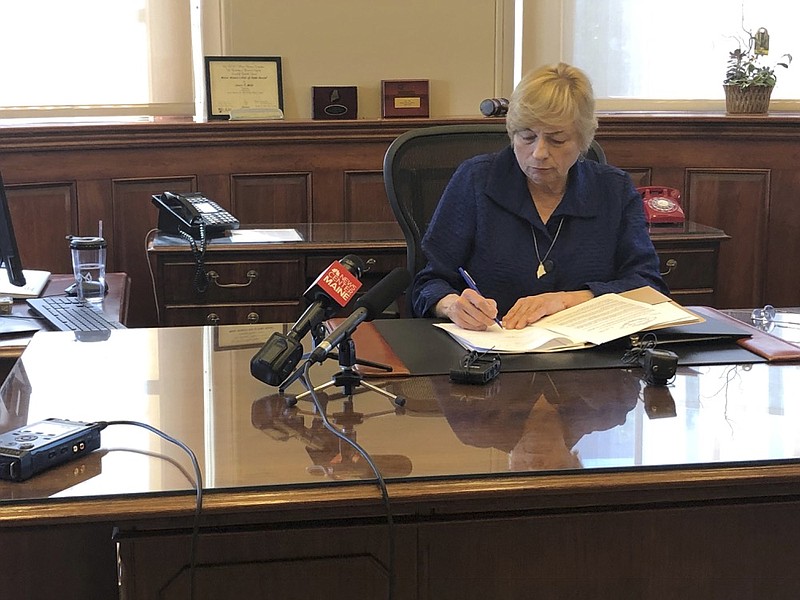 Maine Democratic Gov. Janet Mills signs a bill Wednesday, June 12, 2019, in her office in Augusta, Maine, becoming the eighth state to allow terminally ill people to end their lives with prescribed medication. (AP Photo/Marina Villeneuve)

