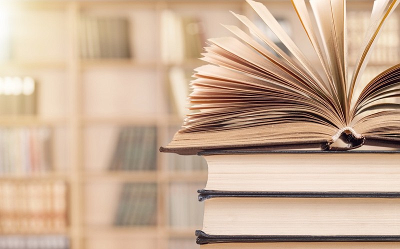 Old stacked books on background book tile library tile / Getty Images
