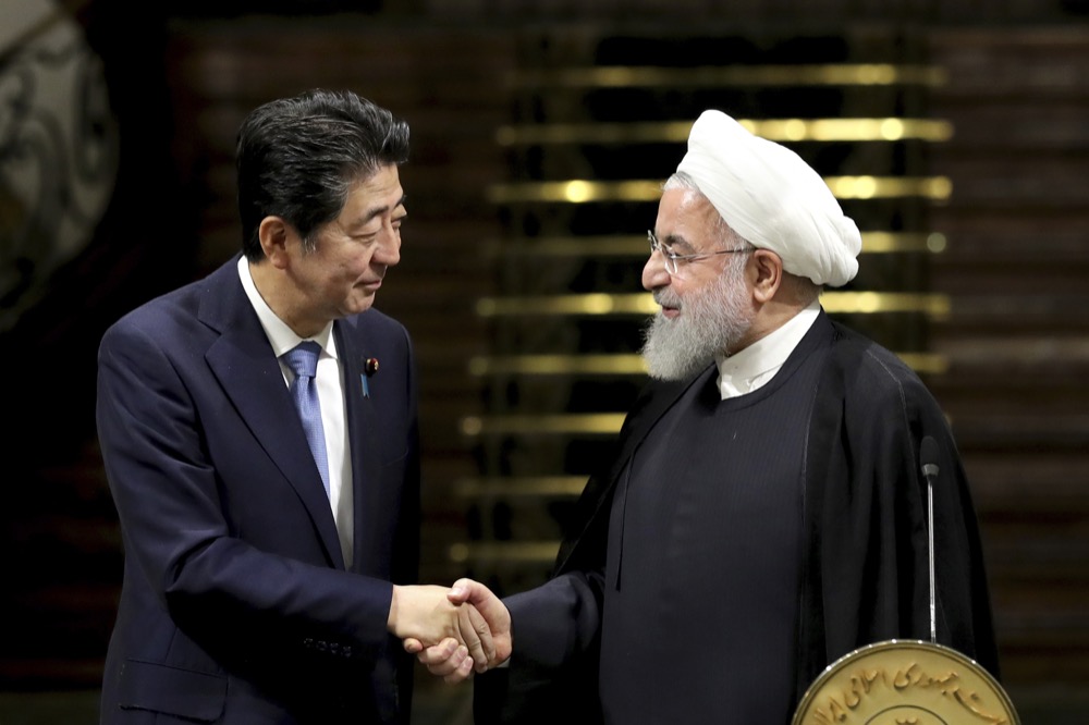 Japanese Prime Minister Shinzo Abe, left, and Iranian President Hassan Rouhani shake hands after their joint press conference at the Saadabad Palace in Tehran, Iran, Wednesday, June 12, 2019. The Japanese leader is in Tehran on an mission to calm tensions between the U.S. and Iran. (AP Photo/Ebrahim Noroozi)