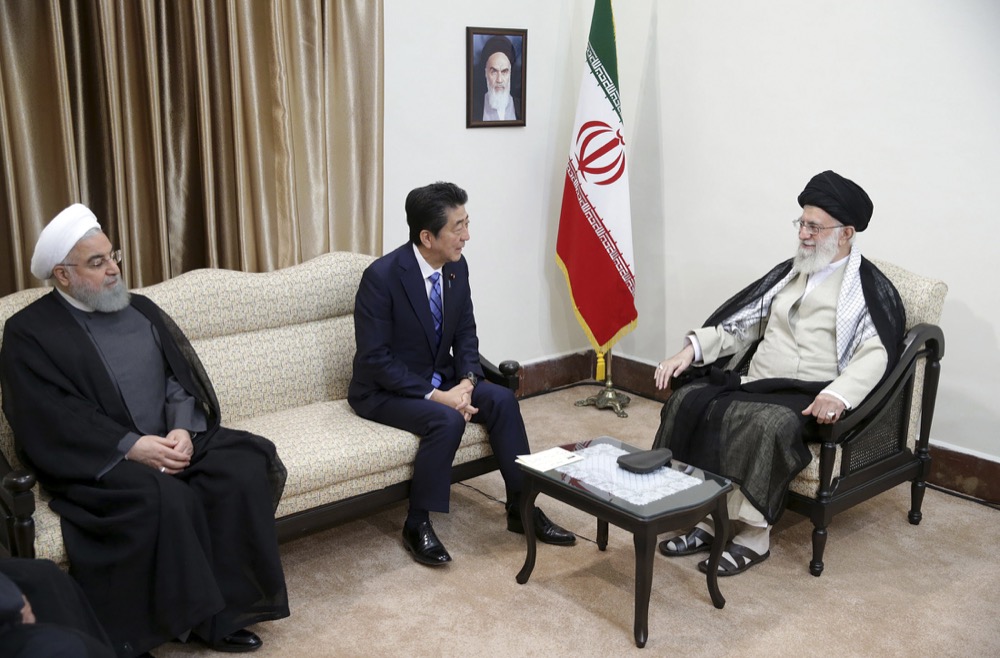 In this picture released by the official website of the office of the Iranian supreme leader, Supreme Leader Ayatollah Ali Khamenei, right, meets with Japanese Prime Minister Shinzo Abe, center, as Iranian President Hassan Rouhani sits at left, in Tehran, Iran, Thursday, June 13, 2019. A portrait of the late Iranian revolutionary founder Ayatollah Khomeini hangs on the wall. (Office of the Iranian Supreme Leader via AP)