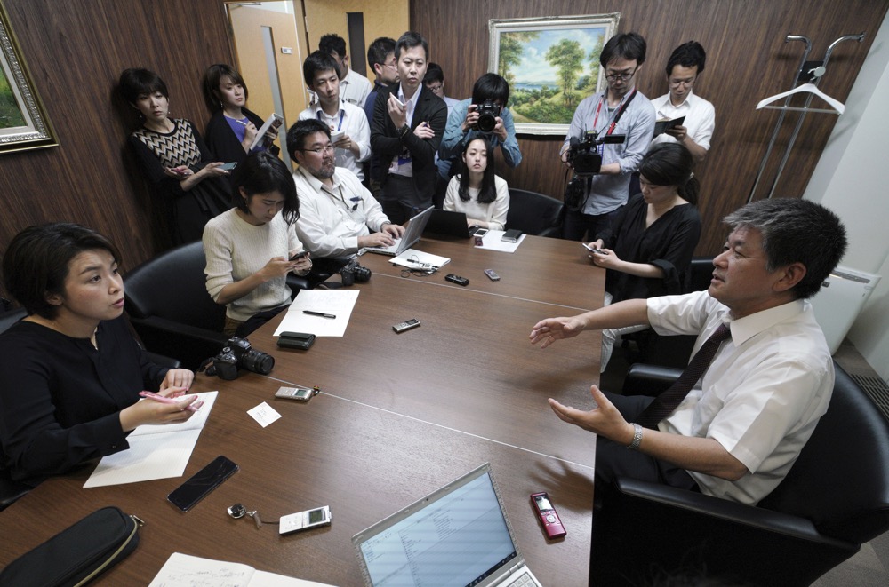 Michio Yube, right, director and general manager of administrative department of Kikuka Sankyo Co., LTD., owner of the Kokuka Courageous, speaks tojournalists on the Kokuka Courageous, which was attacked near the Strait of Hormuz, at Kikuka Sankyo Co., LTD. Thursday, June 13, 2019, in Tokyo. (AP Photo/Eugene Hoshiko)