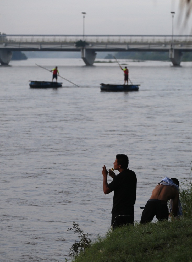A migrant who has been working locally shaves alongside the Suchiate River after bathing with three other migrant who have also found work, in Ciudad Hidalgo, Mexico, at sunrise on Friday, June 14, 2019. Raftsmen and riverfront business operators said the flow of migrants through the crossing has decreased noticeably since the announcement a few days ago that Mexico's new National Guard would be deploying to the border. (AP Photo/Rebecca Blackwell)