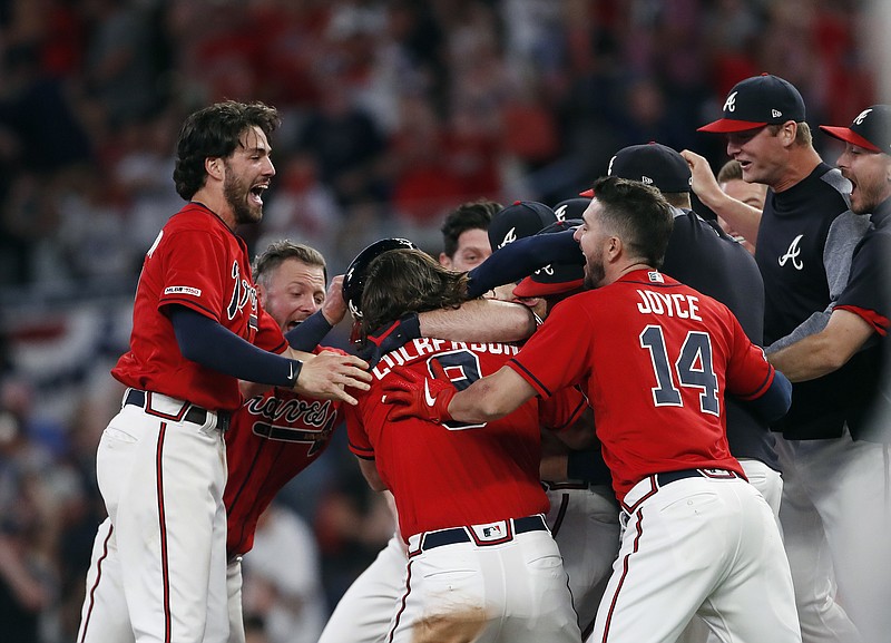 The Atlanta Braves mob Brian McCann after he hit a two-run single in the ninth inning of Friday's home game against the Philadelphia Phillies for a 9-8 comeback victory.