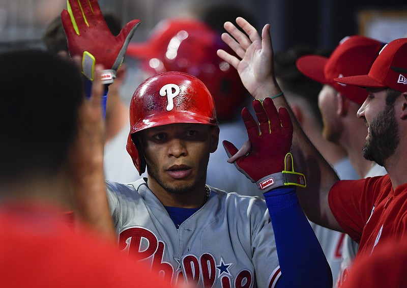 Philadelphia Phillies second baseman Cesar Hernandez is congratulated in the dugout after hitting a home run during the fourth inning of Saturday's game against the host Atlanta Braves.