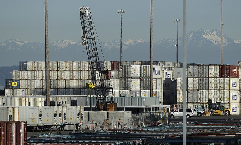 FILE - In this May 10, 2019 file photo, a worker walks near truck trailers and cargo containers at the Port of Tacoma in Tacoma, Wash. Hundreds of businesses, trade groups and individuals have written to complain about President Donald Trump's threat to impose tariffs on the remaining $300 billion in Chinese goods that he hasn't already hit with 25% import taxes, saying the additional import taxes would drive up prices for consumers, squeeze profits and leave U.S. companies at a competitive disadvantage to foreign rivals that aren't subject to higher taxes on the vital components they buy from China.  (AP Photo/Ted S. Warren, File)