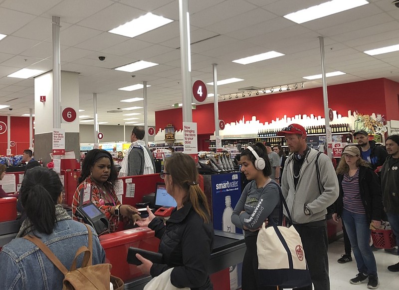 Customers wait on a long check out line at a Target store in San Francisco on Saturday, June 15, 2019. Target suffered a technological glitch that stalled checkout lines at its stores worldwide Saturday, exasperating shoppers and eating into sales at a prime time for retailers. The outage periodically prevented Target's cashiers from scanning merchandise or processing transactions. Self-checkout registers also weren't working at times, causing massive lines in some stores. (AP Photo/Michael Liedtke)

