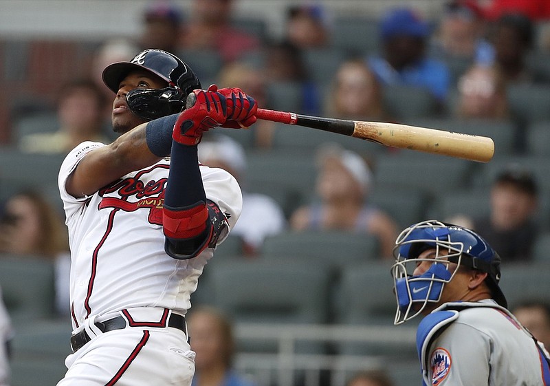 Atlanta Braves' Ronald Acuna Jr., left, follows through on a solo home run as New York Mets catcher Wilson Ramos, right, looks on in the first inning of a baseball game Monday, June 17, 2019, in Atlanta. (AP Photo/John Bazemore)