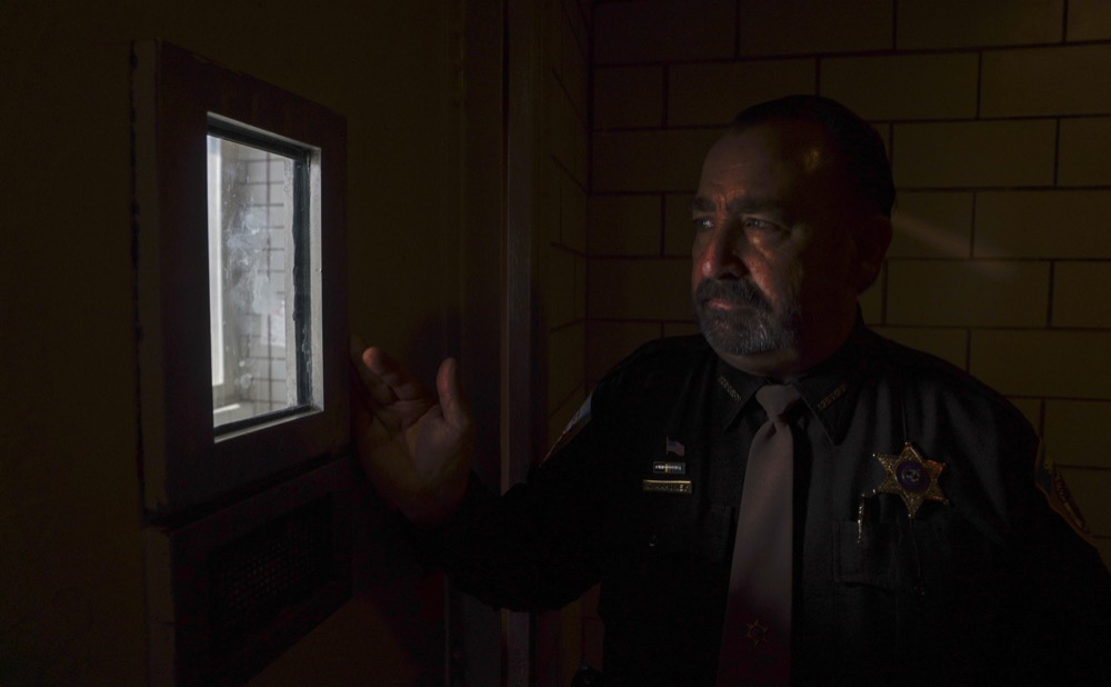 **HOLD FOR STORY BY SHARON COHEN**Dane County Sheriff David Mahoney looks through a small window in a solitary confinement cell in the Dane County jail Tuesday, May 14, 2019, in Madison, Wis. (AP Photo/Morry Gash)