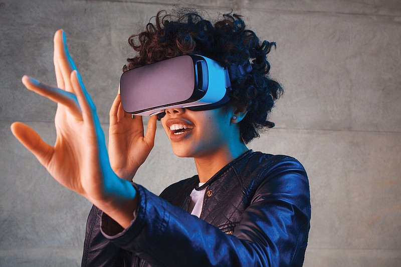 Amazed young woman touching the air during the VR experience. / Getty Images/iStockphoto/max-kegfire