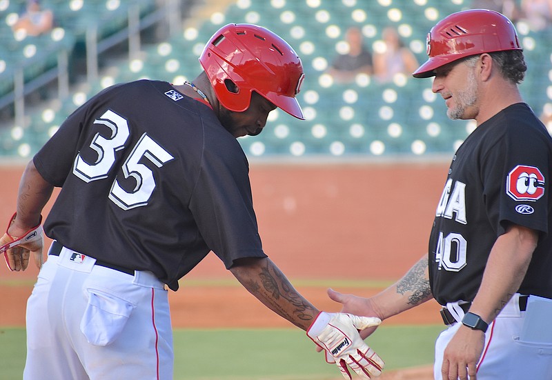 Chattanooga shortstop Alfredo Rodriguez high-fives third-base coach Darren Bragg in the first inning of a Southern League contest Thursday night against Birmingham at AT&T Field. The Lookouts won 10-9 to open the league's second half.